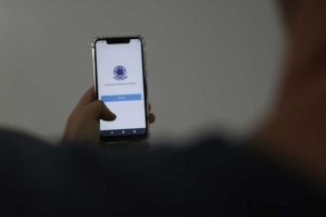 Homem segura celular com o aplicativo da Carteira de Trabalho Digital aberto