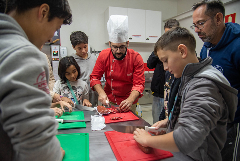 Crianças acolhidas no Parque da Oktoberfest aprendem e se divertem em aula de culinária